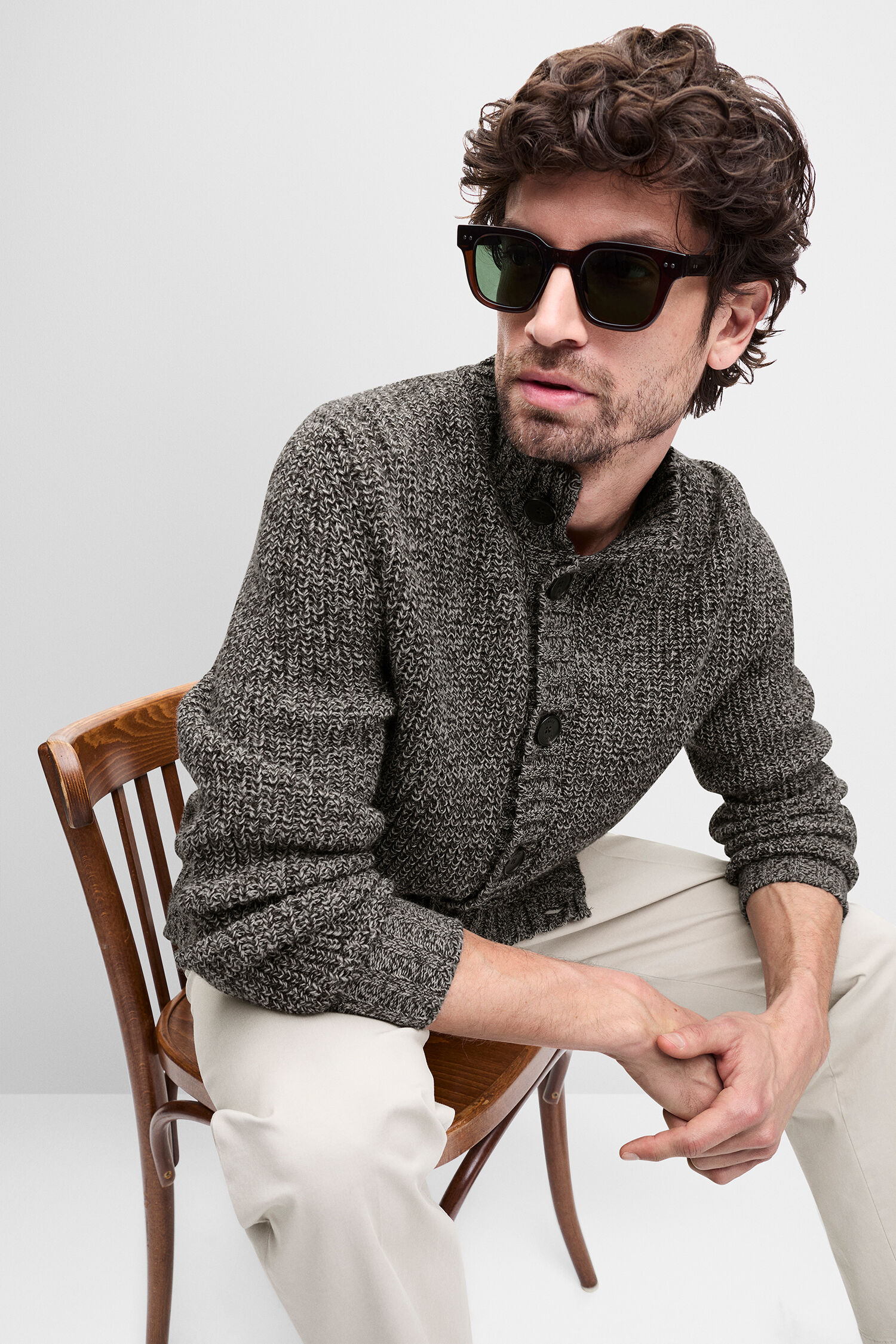 Sonnenbrille,  Cardigan,  Strickpullover,  Beigenehose,  Stuhl