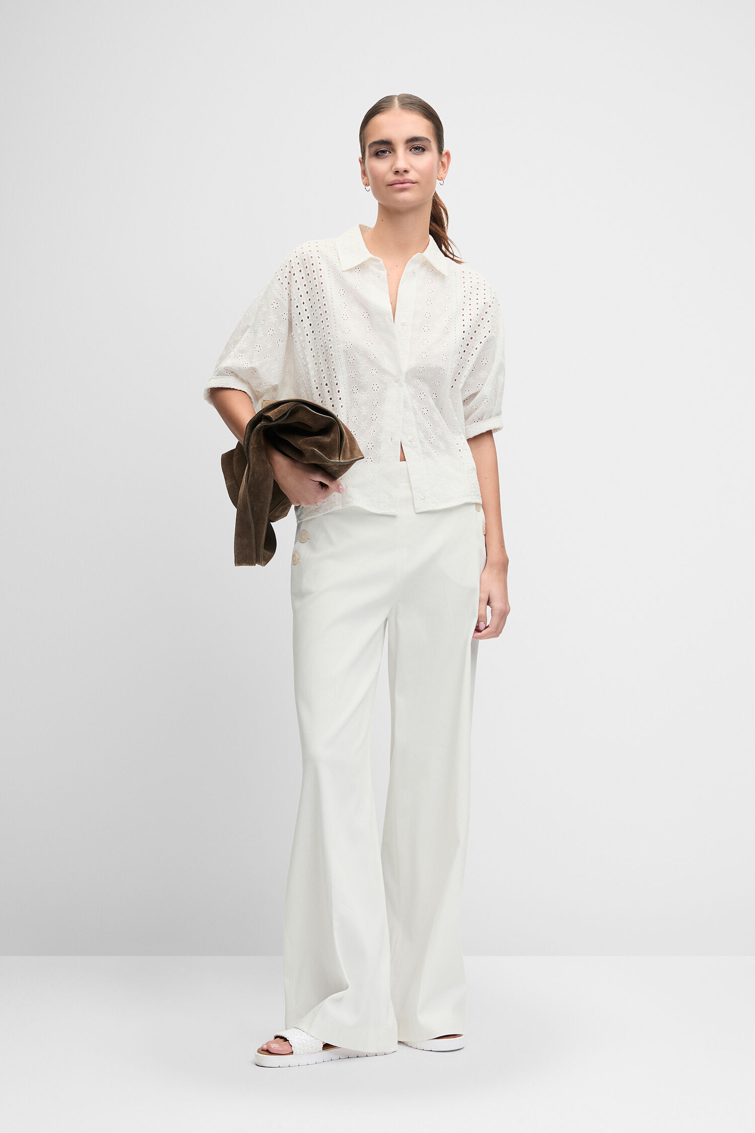 Weißes Oberteil, Weites Beinkleid, Perforiertes Muster, Lederjacke (braune), gehalten, Weiße Hose