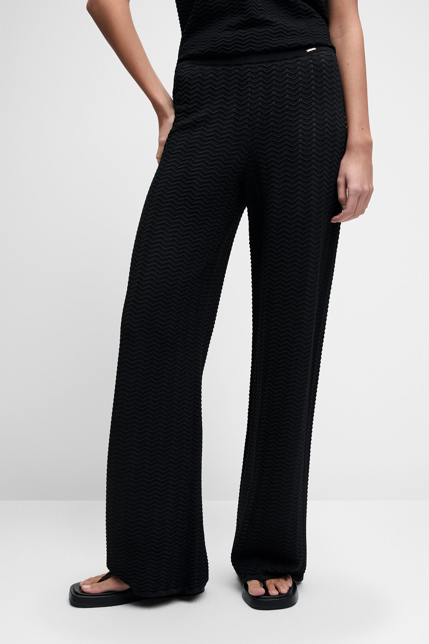 black outfit, jumpsuit, palazzo pants, textured fabric, sunglasses