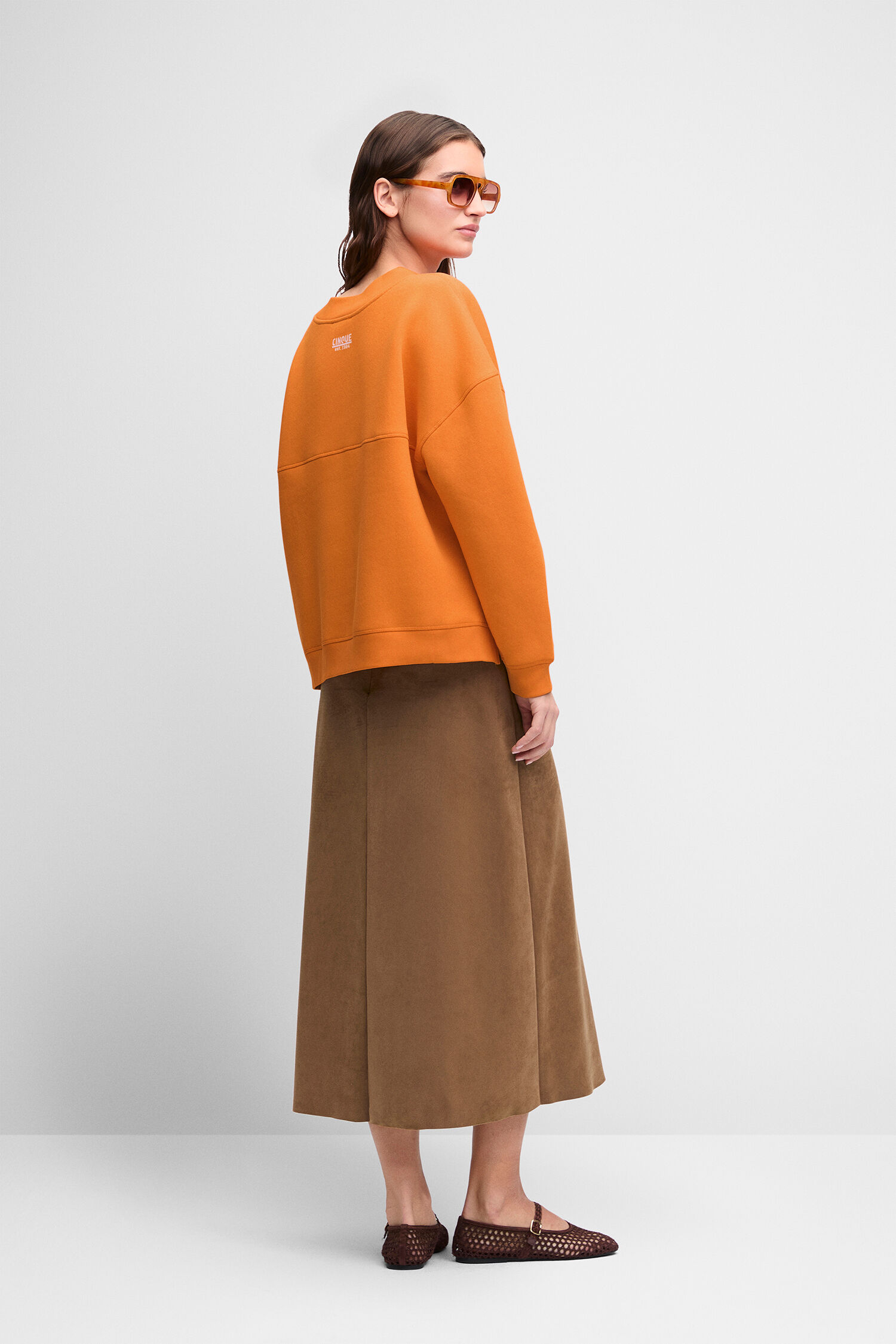 orangeer Pullover, oversized Sweatshirt, braun Midi-Rock, Loafers, Sonnenbrille