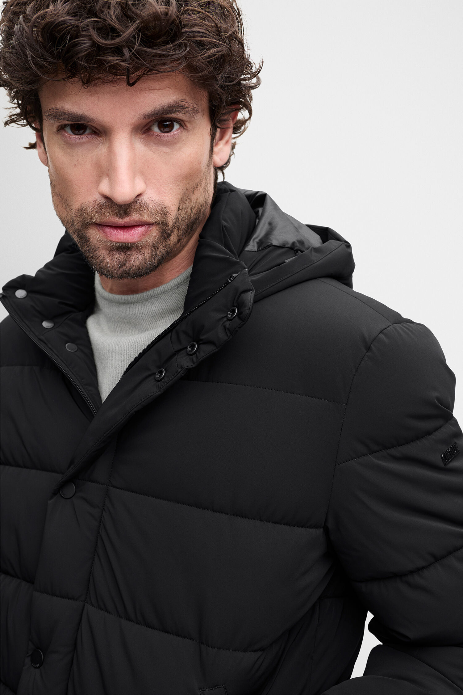 puffer jacke, schwarz, reissverschluss, graue hose, kapuze? neutered